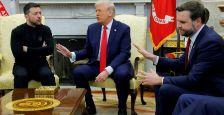 Donald Trump seated in the Oval Office during a tense political confrontation
